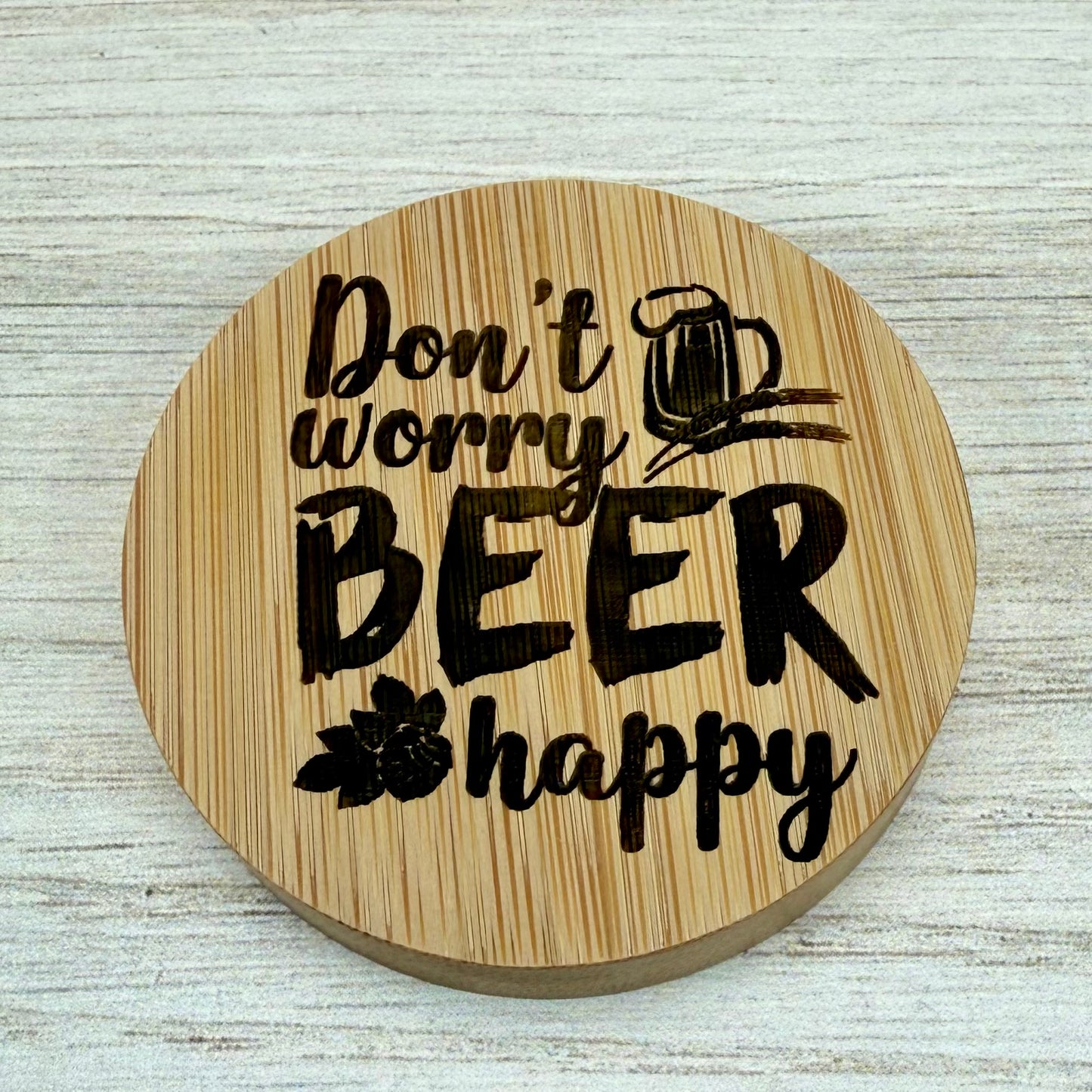 Round laser‑engraved bottle opener with playful “Don’t Worry, Beer Happy” lettering.