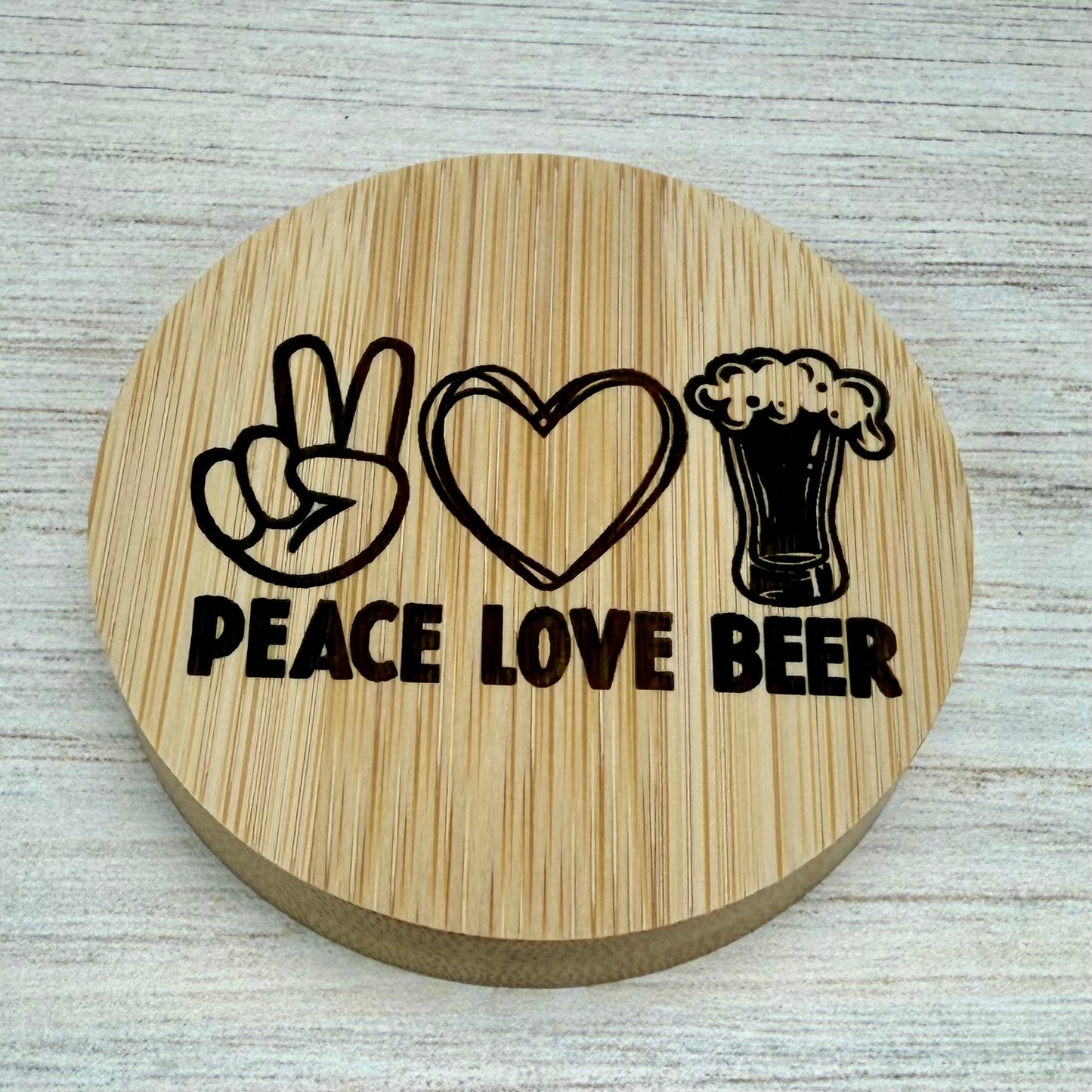 Round laser‑engraved bottle opener with “Peace, Love & Beer” design, ideal for parties or gifts.