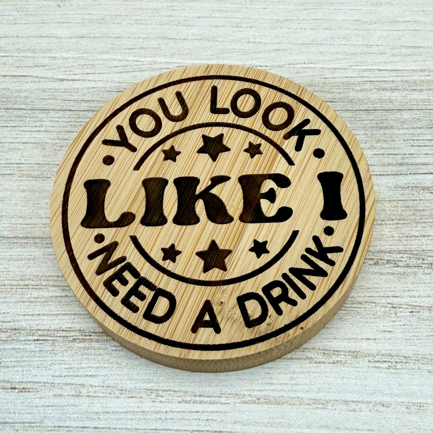 Round laser‑engraved bottle opener with humorous “You Look Like I Need a Drink” design, perfect for parties or gifts.