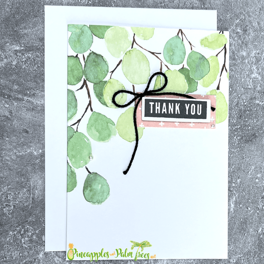 Thank You greeting card with stylized green leaves illustration on the front cover with blank writing space.