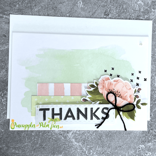 Thank you greeting card in pink and green color scheme showing “THANKS” on front cover.
