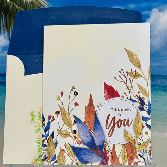 Greeting card “Thinking of You” with blue leaves illustration on the front cover.