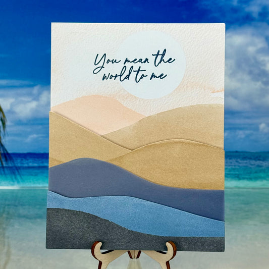 Romantic greeting card with mountain illustration and the message “You Mean the World to Me” on the front.