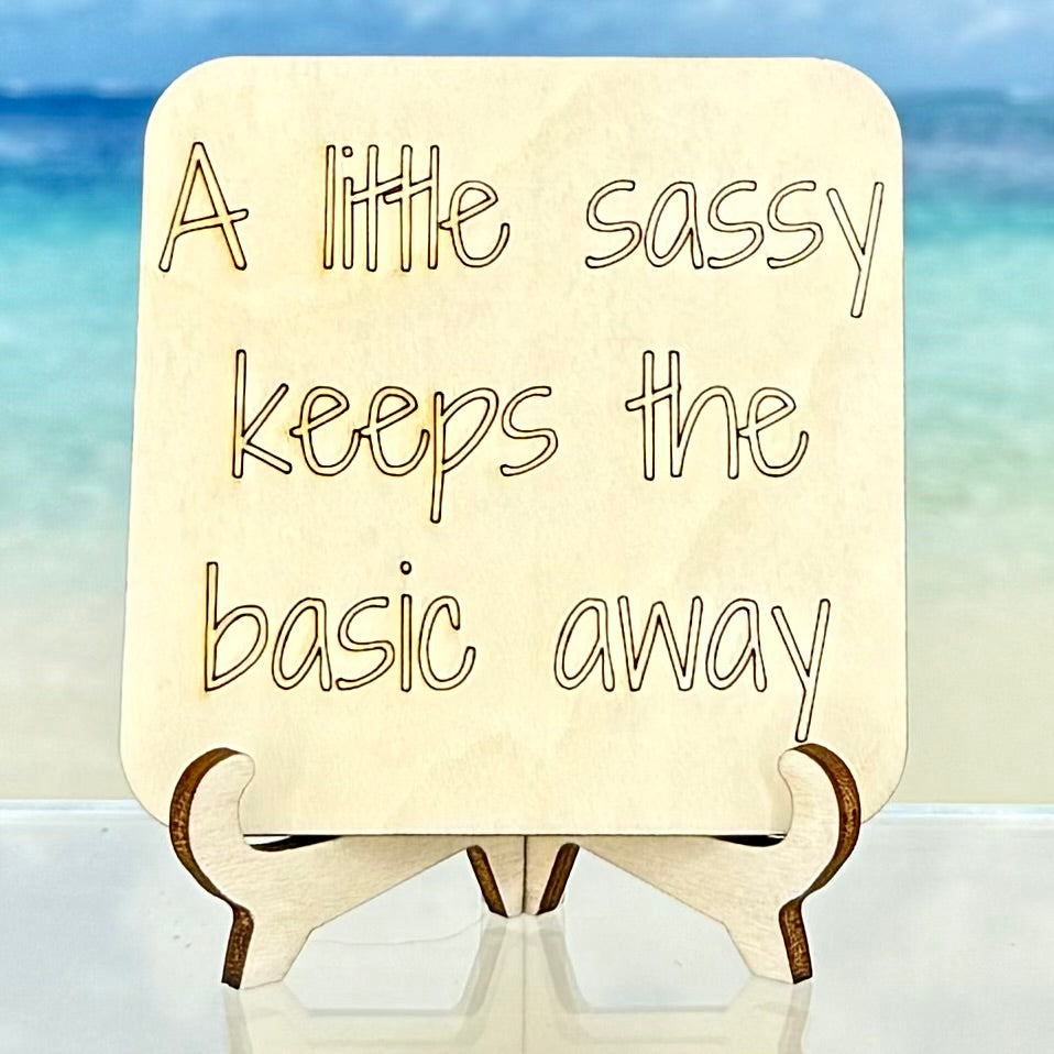 Laser-cut wooden fridge magnet engraved with the quote ‘A Little Sassy Keeps the Basic Away’ — handcrafted, strong magnet attached, perfect for adding humor to any kitchen or home.