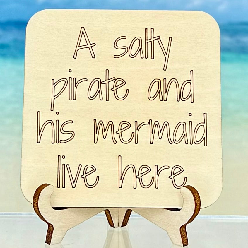 Laser-cut wooden fridge magnet engraved with the phrase ‘A Salty Pirate and His Mermaid Live Here’ — handcrafted coastal-themed décor with a strong magnet backing, perfect for beach homes or gift giving.