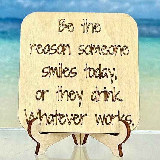 Laser-cut wooden fridge magnet engraved with the quote ‘Be the reason someone smiles today… or they drink! Whatever works.’ — handcrafted décor gift with strong magnet backing.