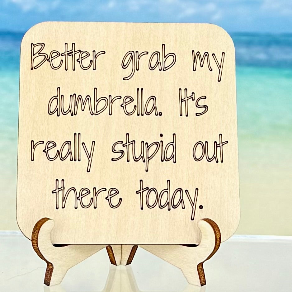 Laser-cut wooden fridge magnet engraved with the quote ‘Better Grab My Dumbrella. It’s Really Stupid Out There Today.’ — handcrafted and humorous décor piece, strong magnet backing, perfect for kitchen or office.