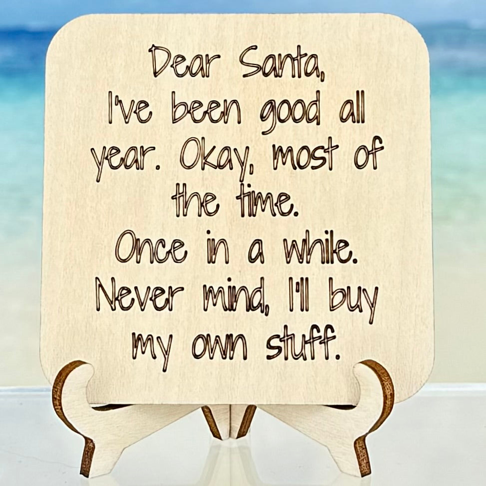 Laser-cut wooden fridge magnet engraved with the quote ‘Dear Santa, I’ve been good all year. Okay, most of the time. Once in a while. Never mind, I’ll just buy my own stuff.’ — handcrafted humorous décor with strong magnet backing.