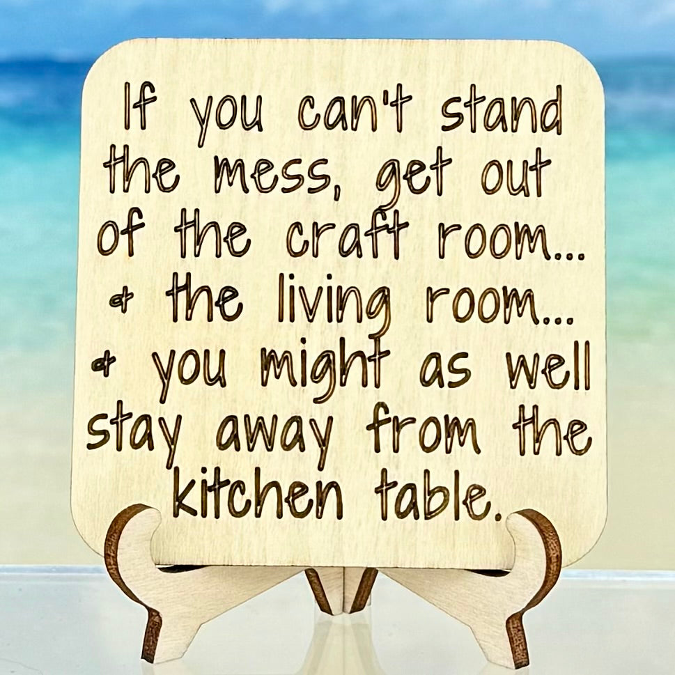 Laser-cut wooden fridge magnet engraved with the quote ‘If you can’t stand the mess, get out of the craft room, and the living room, and you might as well stay away from the kitchen table’ — handcrafted humor décor piece for makers and home-life lovers.