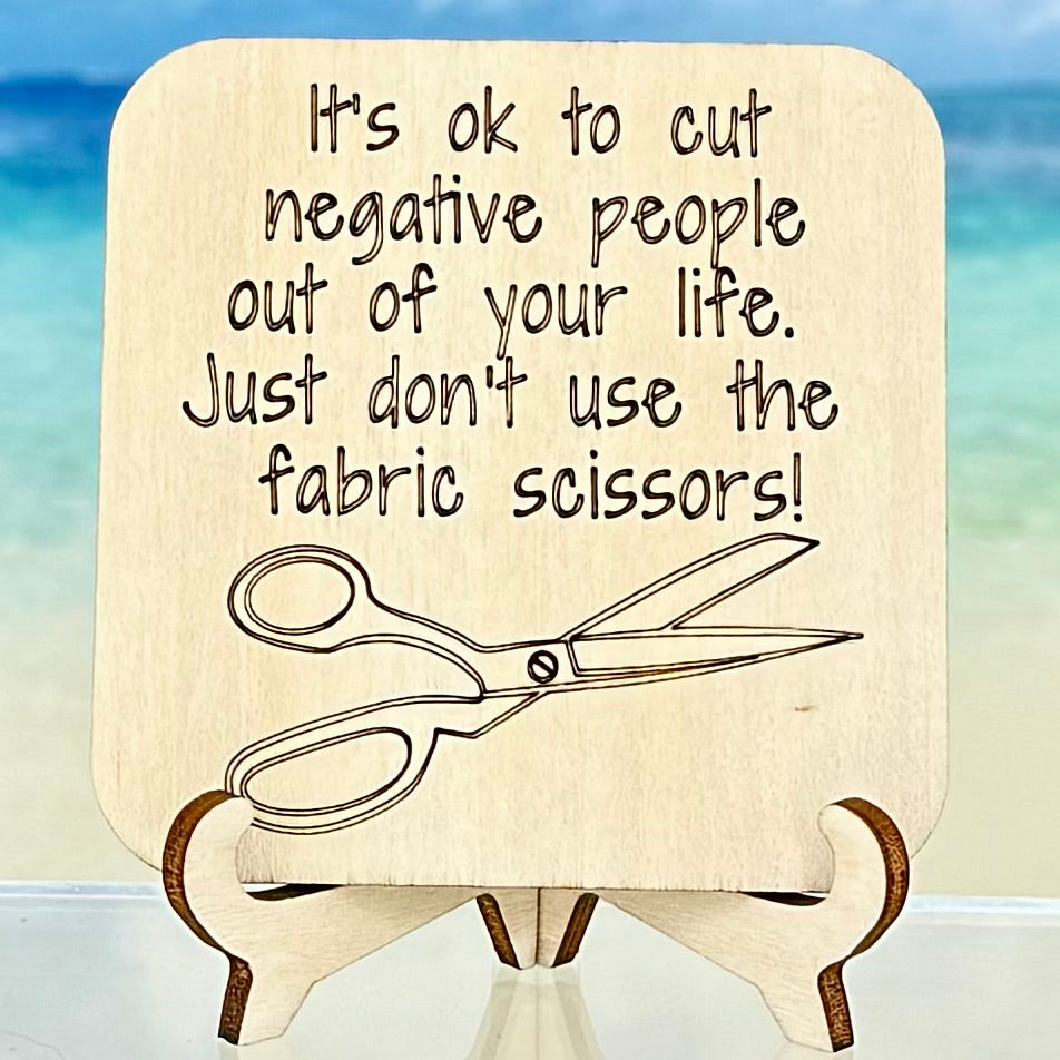 Laser-cut wooden fridge magnet engraved with the quote ‘It’s ok to cut negative people out of your life. Just don’t use your fabric scissors.’ — handcrafted décor piece for crafters, with strong magnet backing.