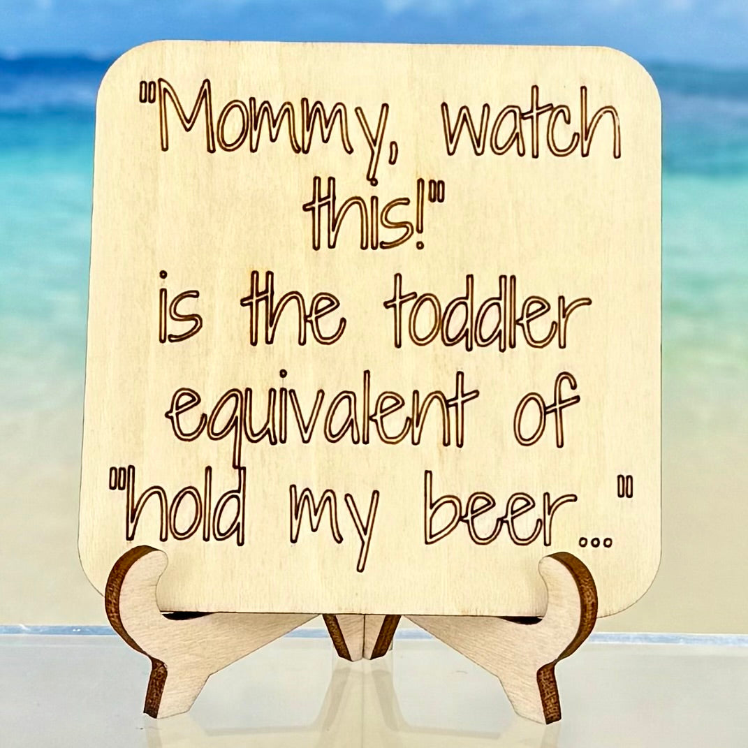 Laser-cut wooden fridge magnet engraved with the quote ‘Mommy, Watch This! – the toddler equivalent of “Hold My Beer”’ — handcrafted humorous décor for parents and gift-givers.