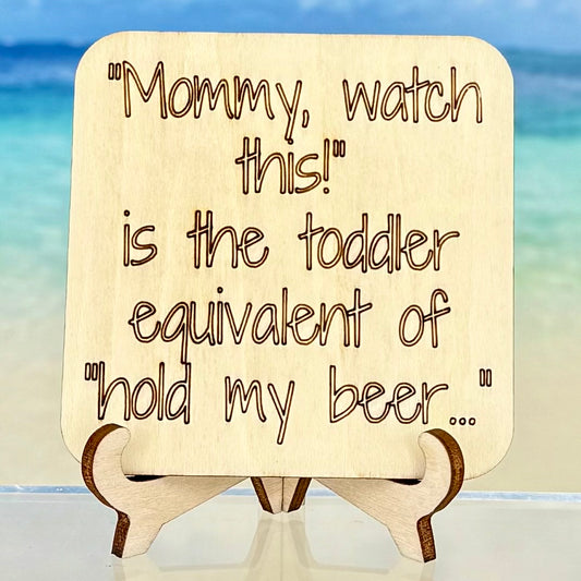 Laser-cut wooden fridge magnet engraved with the quote ‘Mommy, Watch This! – the toddler equivalent of “Hold My Beer”’ — handcrafted humorous décor for parents and gift-givers.