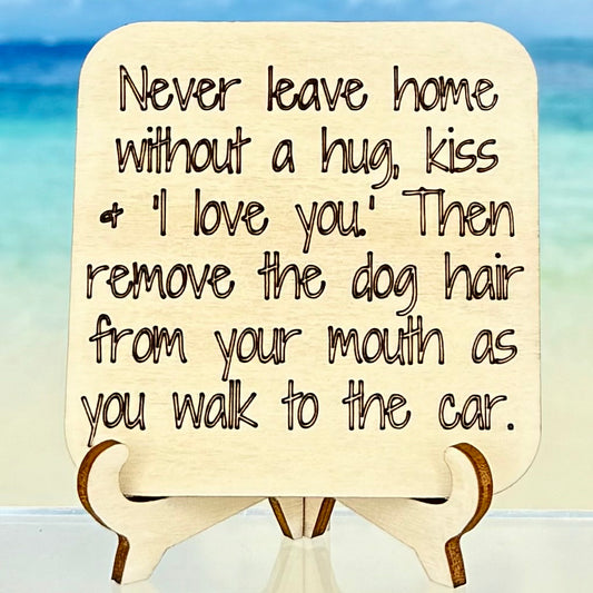 Laser‑cut wooden fridge magnet engraved with the quote ‘Never leave home without a kiss, a hug and “I love you.” Then remove the dog hair from your mouth as you walk to the car.’ — handcrafted décor piece with strong magnet backing, perfect gift for dog lovers and affectionate homes.
