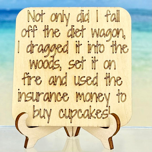 Laser-cut wooden fridge magnet engraved with the quote ‘Not only did I fall off the diet wagon—I dragged it into the woods, set it on fire and used the insurance money to buy cupcakes.’ — handcrafted humorous décor with strong magnet backing.